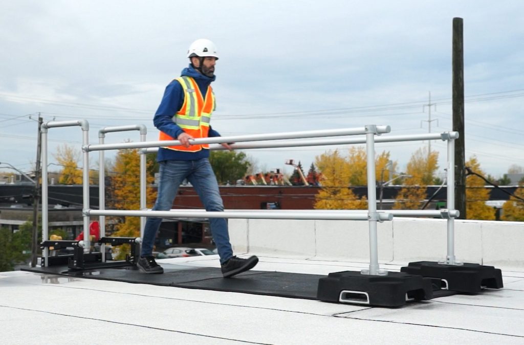 A worker make his way trough the ladder stabilizer guardrail