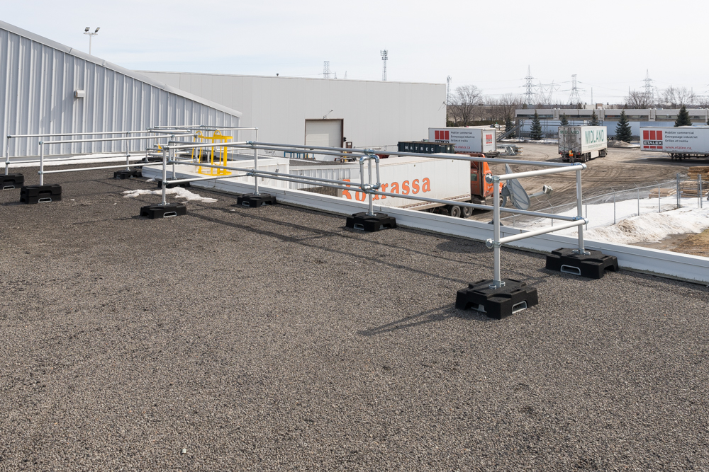 Barrière coulissante autoportante installé sur un toit plat pour faciliter le dépôt de matériel.