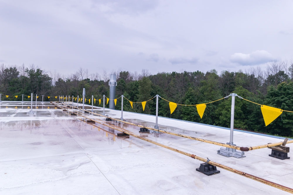 A permitier of permanent warning line creates a safe work zone on a roof