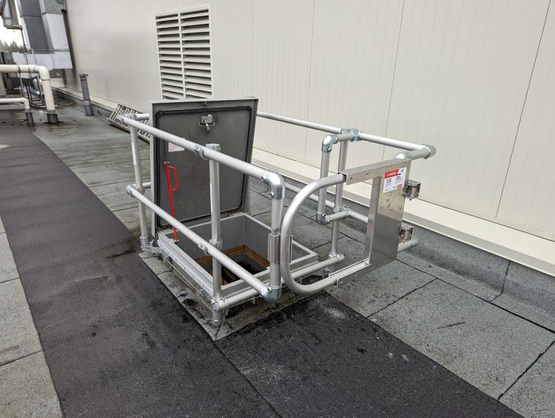 Roof access hatch equipped with safety railing