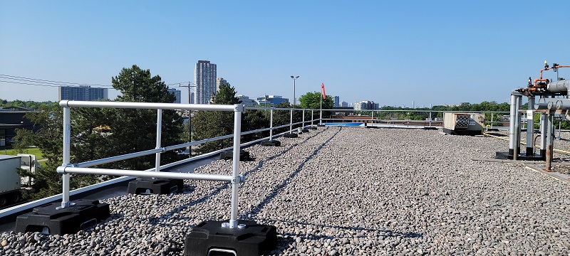 Long section of rooftop guardrails on ballasted roof in Ontario, Canada